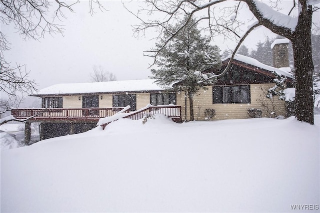 view of front of home with a deck and brick siding