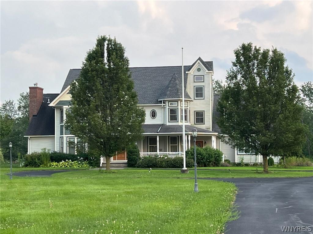 victorian-style house with covered porch and a front yard