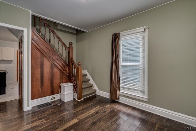 stairs with a wealth of natural light and hardwood / wood-style flooring