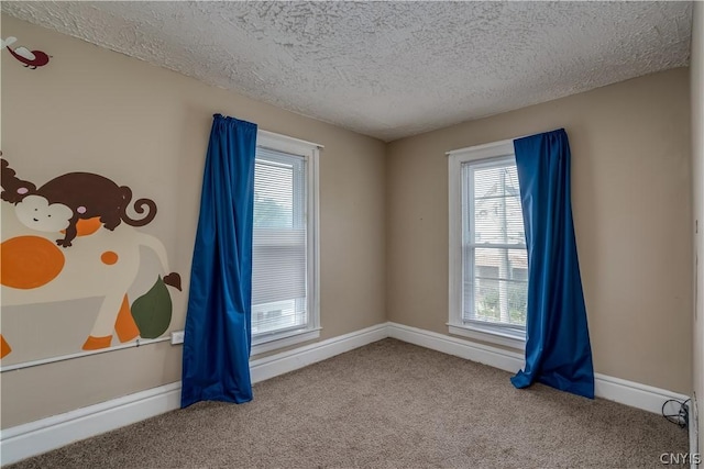 unfurnished room featuring carpet flooring and a textured ceiling