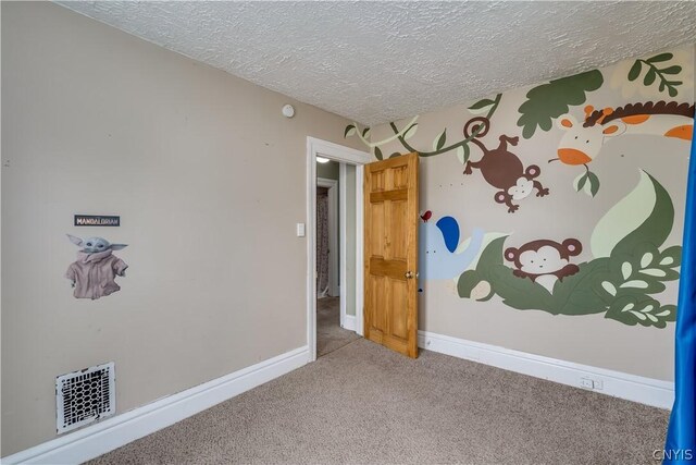 spare room featuring carpet flooring and a textured ceiling