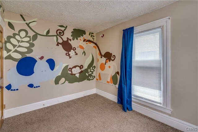 carpeted empty room featuring a textured ceiling