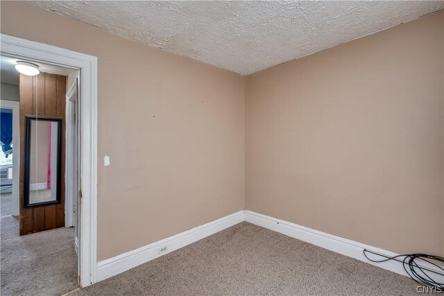 unfurnished room with carpet flooring and a textured ceiling