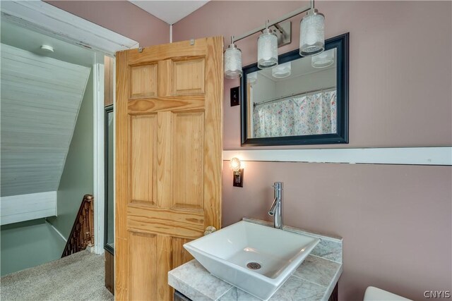 bathroom with sink and lofted ceiling