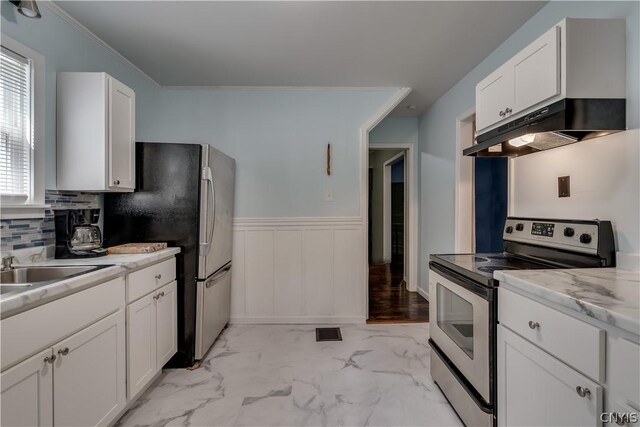 kitchen with appliances with stainless steel finishes, light hardwood / wood-style flooring, white cabinetry, and light stone countertops