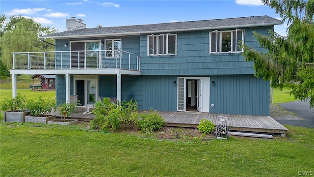 rear view of property with a wooden deck and a lawn