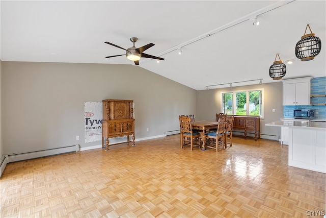 dining area with ceiling fan, light parquet flooring, rail lighting, a baseboard heating unit, and lofted ceiling