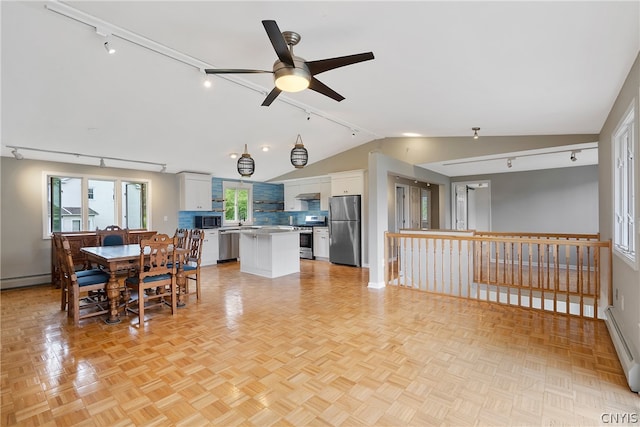 dining room featuring rail lighting, a baseboard heating unit, vaulted ceiling, light parquet floors, and ceiling fan