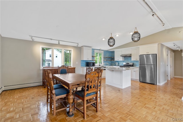 dining room featuring lofted ceiling, light parquet flooring, rail lighting, and a baseboard radiator