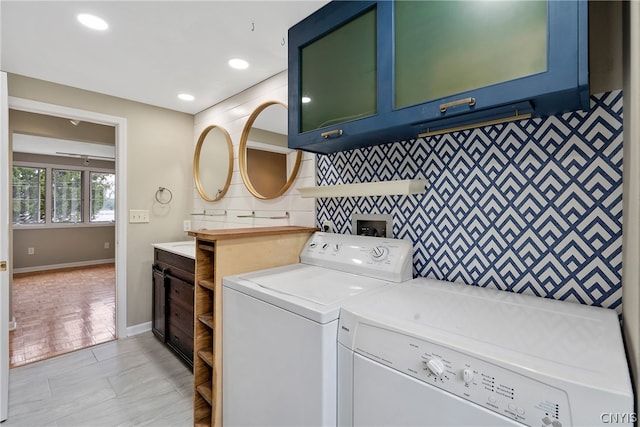 washroom featuring cabinets and washer and clothes dryer