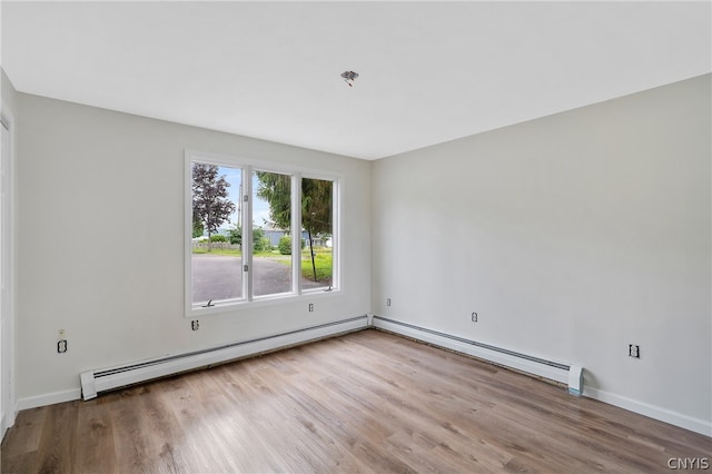 spare room with hardwood / wood-style floors and a baseboard radiator