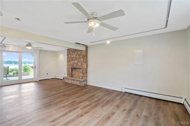 unfurnished living room with ceiling fan, a fireplace, a baseboard radiator, and wood-type flooring