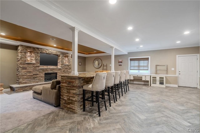 bar with ornamental molding, parquet flooring, and a fireplace