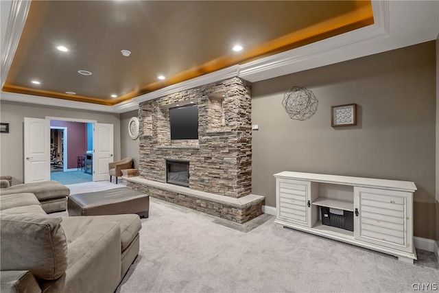 living room featuring a fireplace, a raised ceiling, and carpet flooring