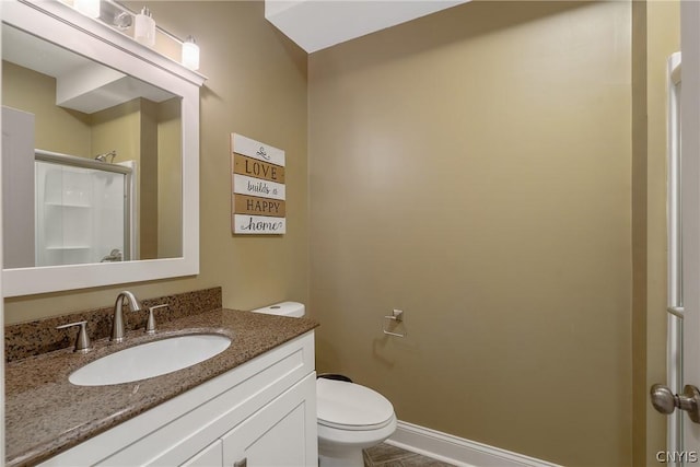 bathroom with vanity, toilet, and a shower with door