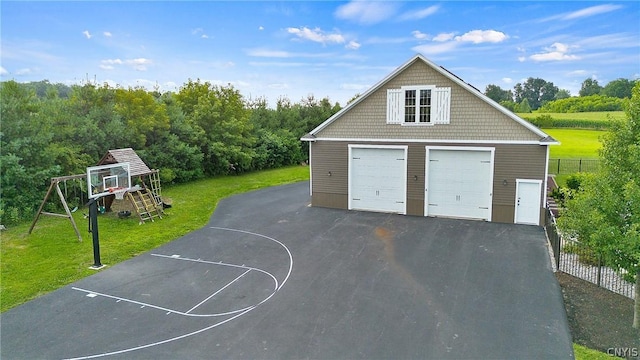 garage featuring basketball court and a lawn