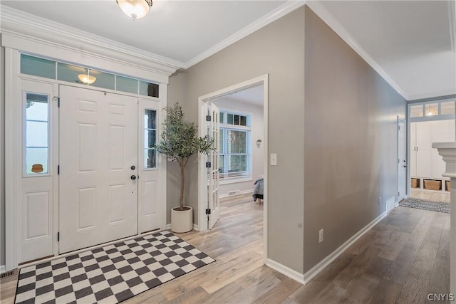 entryway with crown molding and light hardwood / wood-style flooring