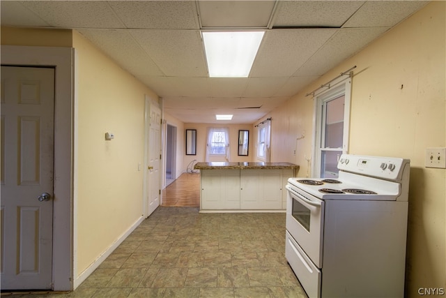 kitchen with electric range, light tile patterned floors, and a paneled ceiling