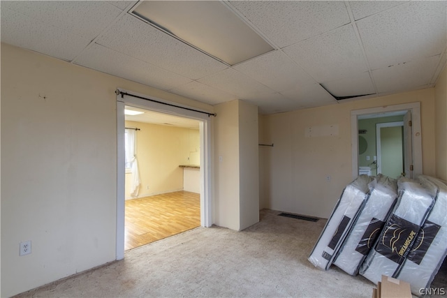 unfurnished bedroom with a drop ceiling and hardwood / wood-style floors