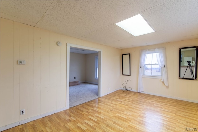 empty room with a drop ceiling and light colored carpet