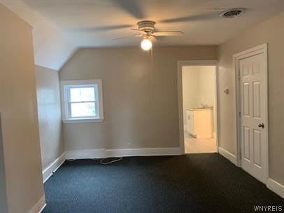 bonus room featuring ceiling fan, vaulted ceiling, and dark colored carpet