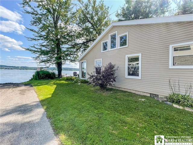 view of home's exterior featuring a water view and a yard