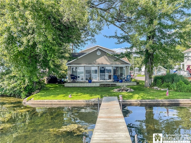 back of house featuring a deck with water view and a yard