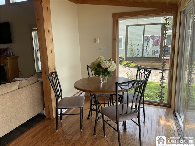 dining area featuring beam ceiling and hardwood / wood-style floors