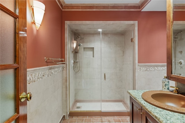 bathroom with tile walls, vanity, crown molding, an enclosed shower, and tile patterned floors