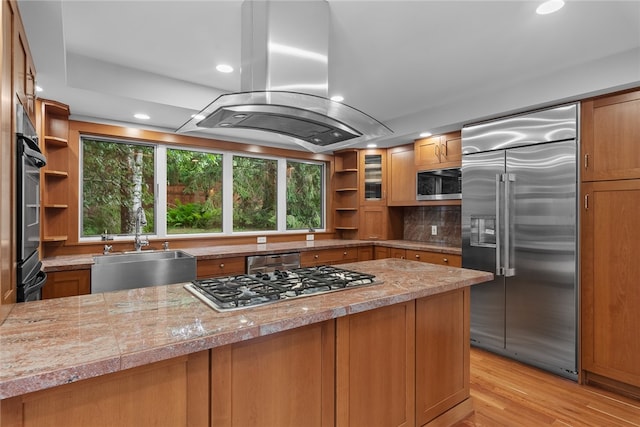 kitchen with light hardwood / wood-style flooring, island exhaust hood, stainless steel appliances, and a healthy amount of sunlight