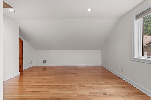 additional living space with lofted ceiling and light hardwood / wood-style floors