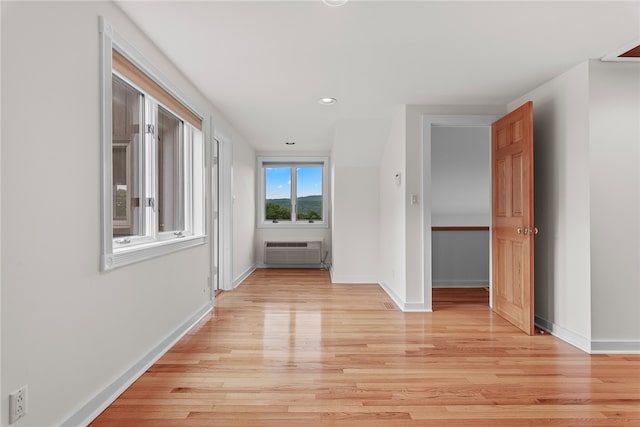 hallway with light hardwood / wood-style floors and a wall mounted air conditioner