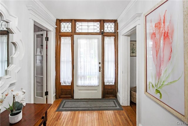 entryway with crown molding and hardwood / wood-style floors