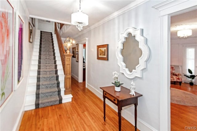 interior space with crown molding, hardwood / wood-style floors, and an inviting chandelier