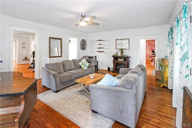 living room featuring ceiling fan, ornamental molding, dark hardwood / wood-style floors, and radiator