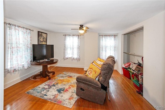 living room with wood-type flooring and ceiling fan