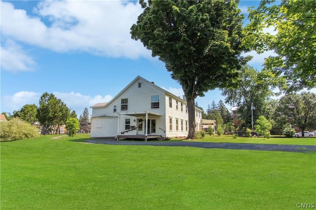 rear view of property with a yard