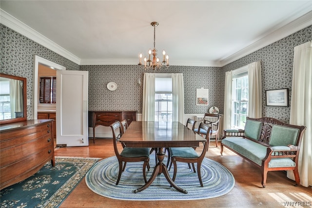 dining room with ornamental molding, light hardwood / wood-style flooring, and a chandelier