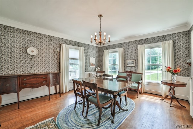 dining space featuring an inviting chandelier, crown molding, and light hardwood / wood-style flooring