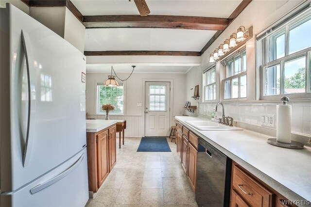 kitchen with white fridge, beam ceiling, light tile patterned floors, and black dishwasher