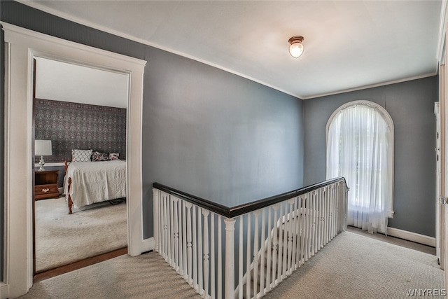 hallway with light colored carpet and crown molding