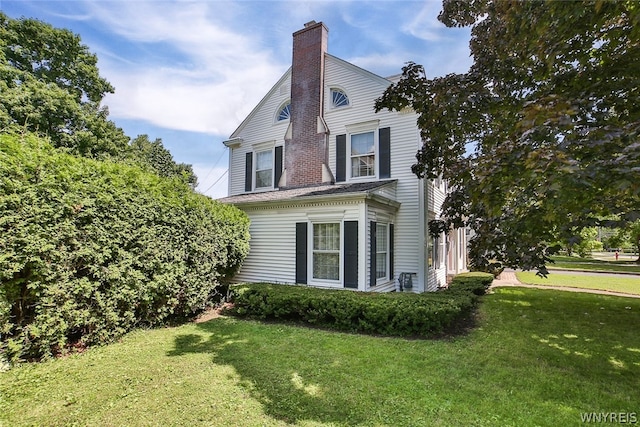 view of side of home with a lawn