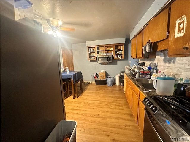 kitchen with sink, light hardwood / wood-style flooring, black range with electric cooktop, and ceiling fan