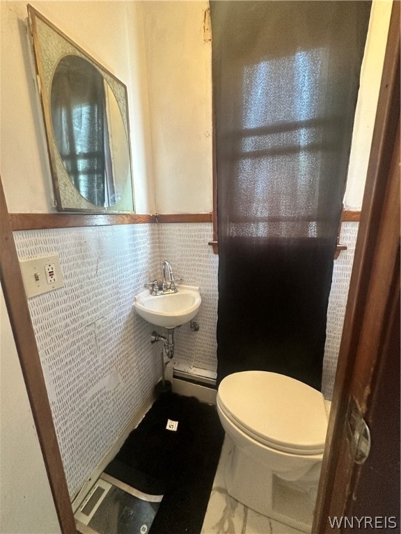 bathroom featuring tile patterned flooring, tasteful backsplash, toilet, tile walls, and a baseboard radiator