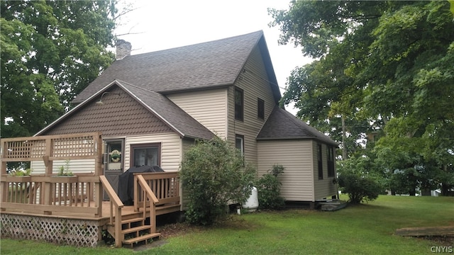 rear view of house featuring a yard and a wooden deck