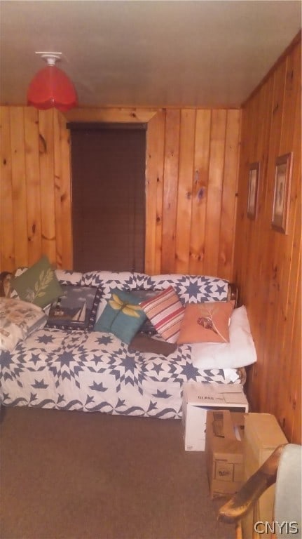 bedroom with wooden walls and carpet