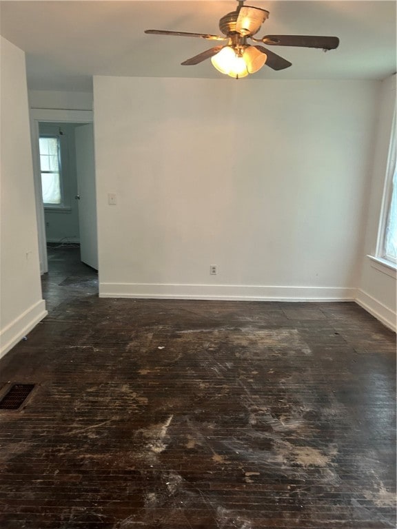 empty room with dark hardwood / wood-style flooring and ceiling fan