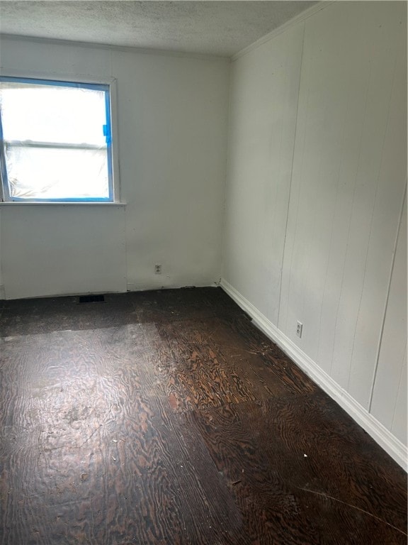 empty room with a textured ceiling and hardwood / wood-style floors