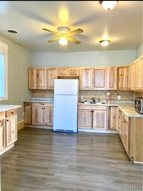 kitchen with tasteful backsplash, white fridge, dark hardwood / wood-style floors, and light brown cabinets