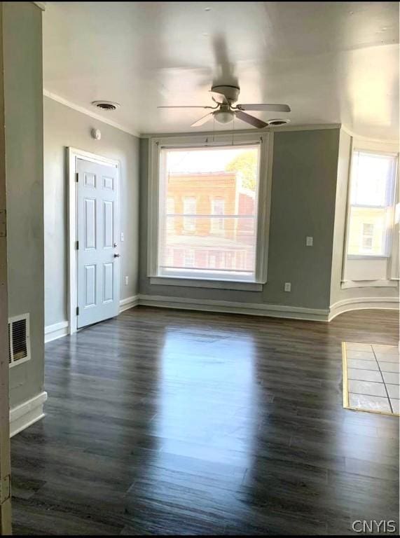 unfurnished room featuring dark hardwood / wood-style flooring, crown molding, and ceiling fan